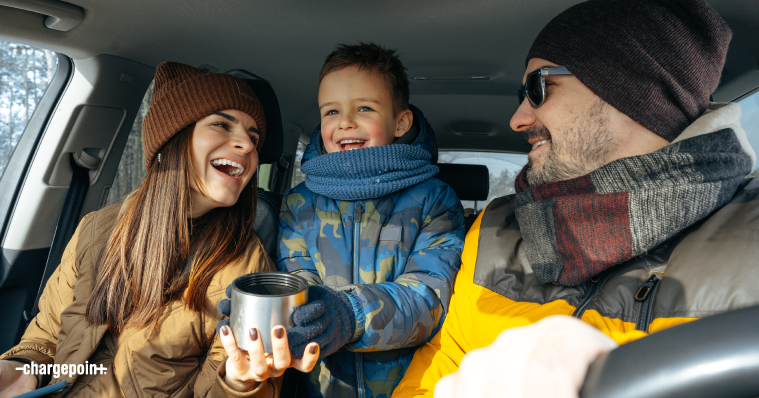 Family in a car sharing laughter and hot drink on a road trip