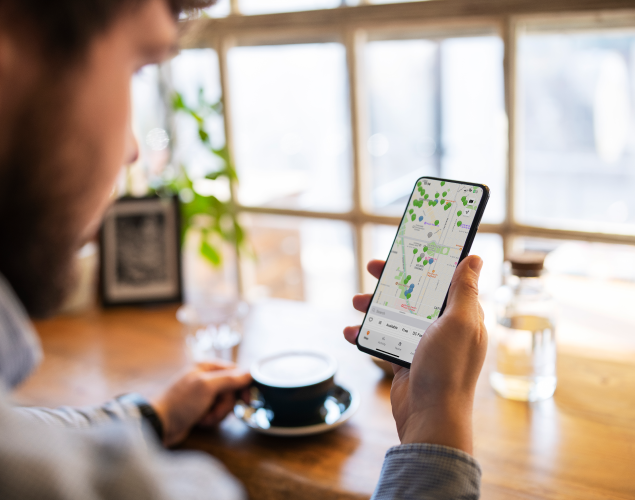 Person looking at ChargePoint app on their phone while having a coffee