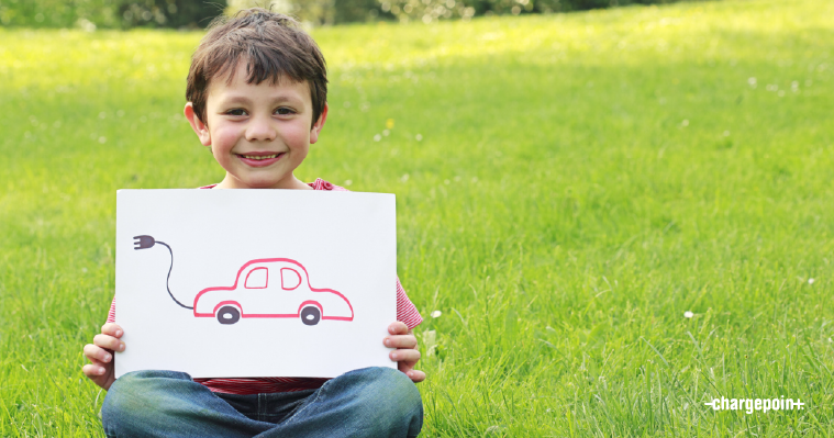 Child holding a drawing of an electric car