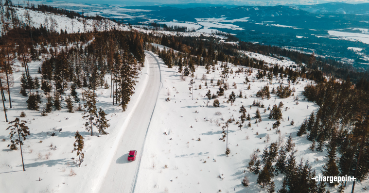 Aerial view of car driving on a snowy road