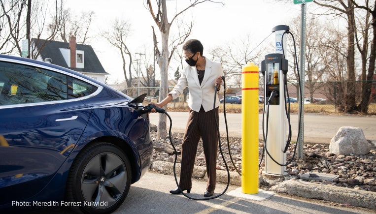 Woman plugging in at a ChargePoint station on campus