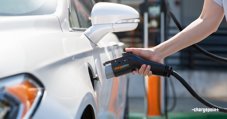 Personne branchant un chargeur ChargePoint à une voiture