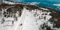 Aerial view of car driving on a snow road