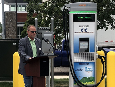Person talking on a podium next to ChargePoint Express 