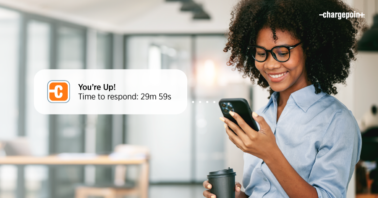 Person checking their phone with smiley face when getting ChargePoint Waitlist notification