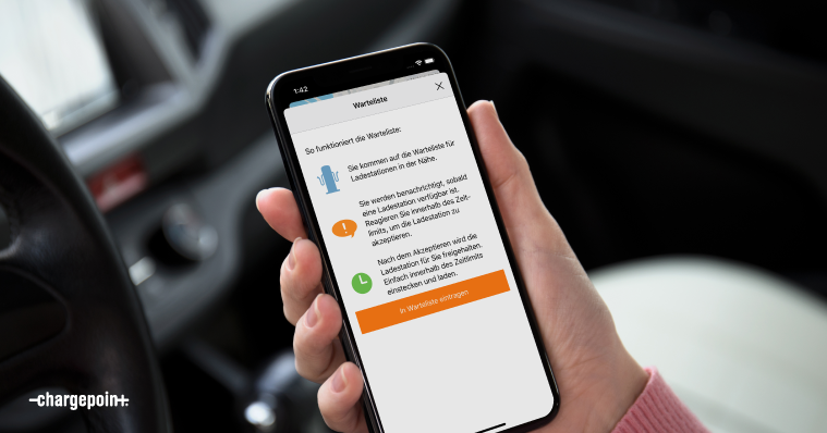 Eine Hand, die ein Handy hält, auf dem der ChargePoint‑Wartelistenbildschirm angezeigt wird.