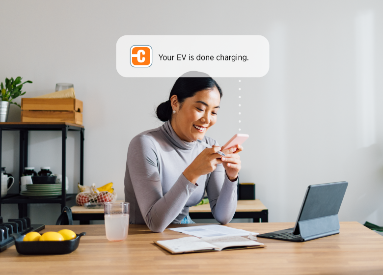 Person looking at their phone for charging notification Person looking at their phone for charging notification
