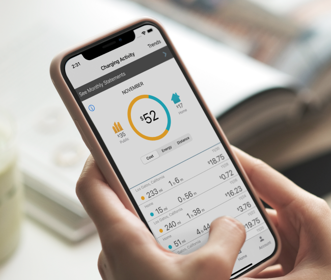 A person holding a smartphone displaying a "Charging Activity" app screen, showing monthly costs, energy usage, and detailed statistics.